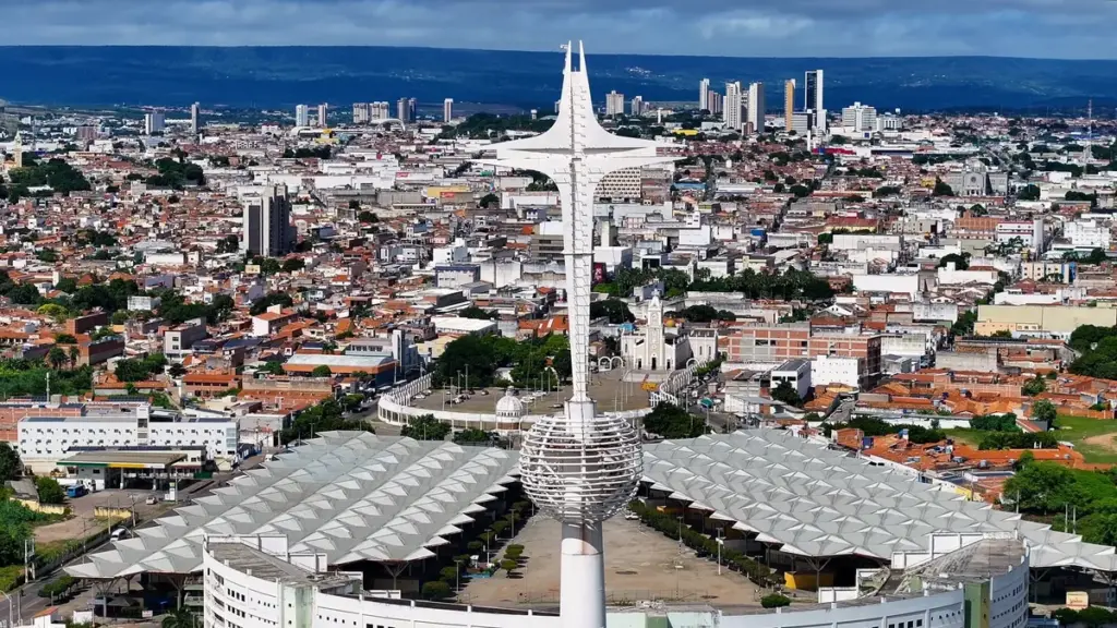 Vista aérea de Juazeiro do Norte com monumento branco e área urbana ao fundo